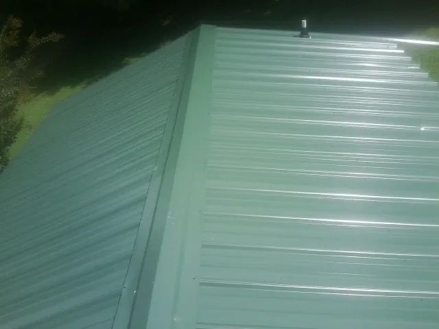 New green metal panels meeting at the ridge of a roof — Flat Roof Repair work by our crew in Azusa
