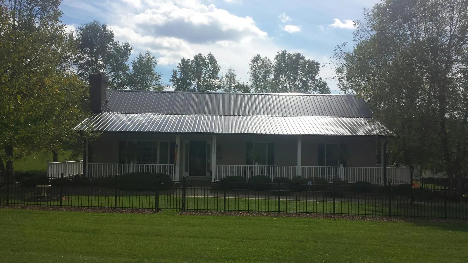 Gray metal roof on a brick ranch with a full width front porch — Gutter Guard Installation work by our crew in Azusa